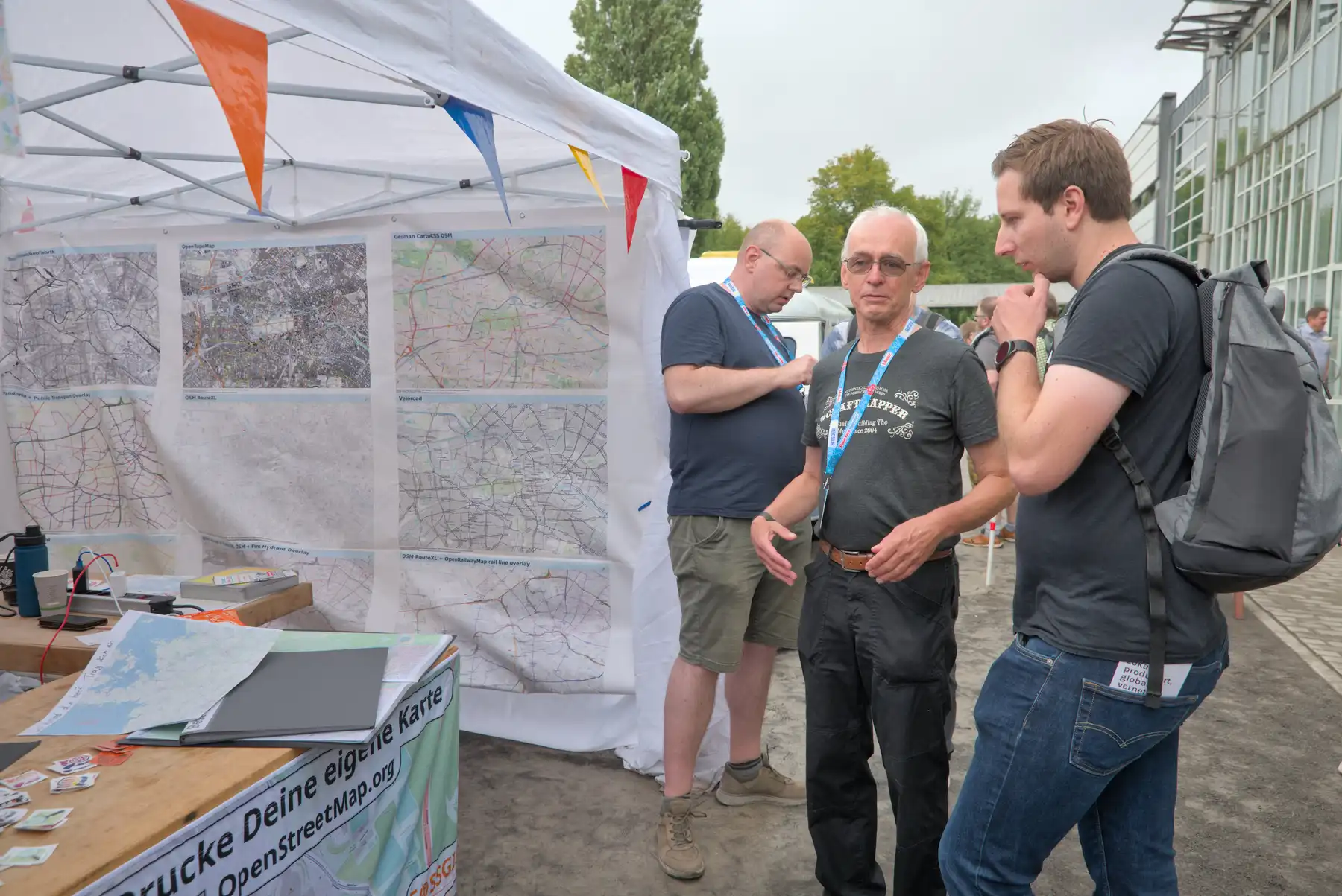 Foto vom OpenStreetMap-Stand im Außenbereich, Menschen stehen davor